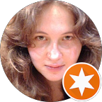 Portrait d'une femme avec des cheveux bouclés, souriant légèrement.